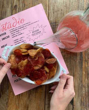 a chips sitting on top of a wooden table and menu with drink