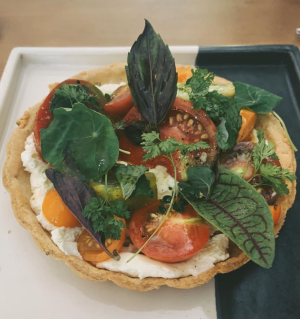 a plate of tomato and cheese tart food on a table