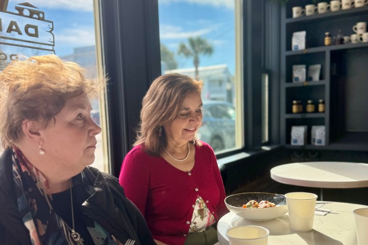 a woman sitting at a table with a plate of food