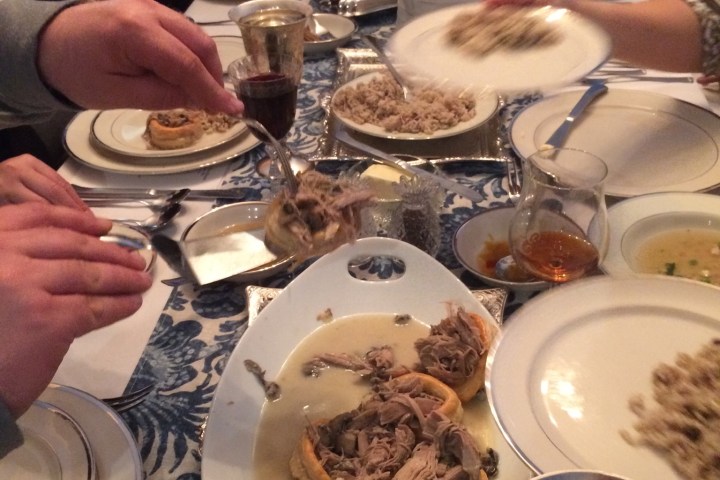 a group of people sitting at a table with a plate of food