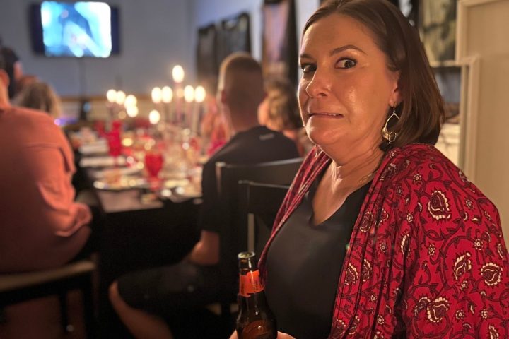 a woman sitting at a table with wine glasses