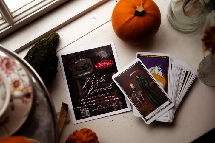 Tarot cards and autumn decor on a table with a pumpkin ghost tour in charleston, sc October haunted tour with dessert