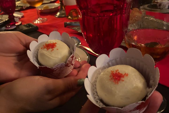 a person holding a plate of food on a table