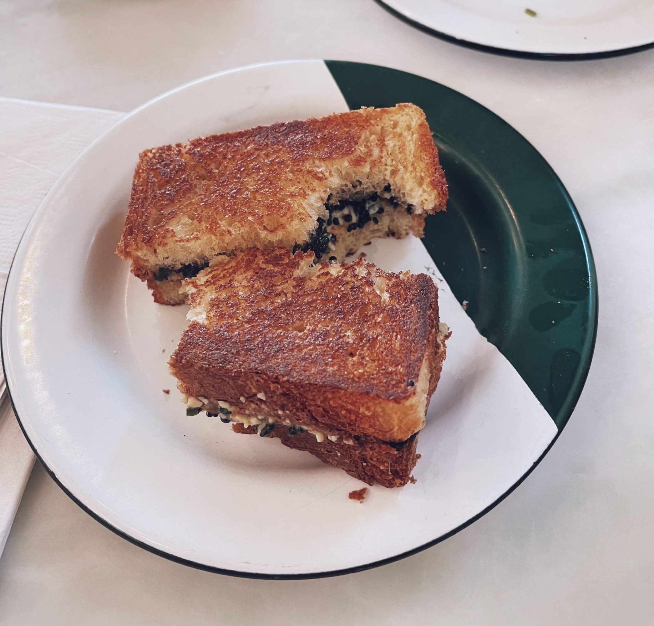 a caviar sandwich on a green and white plate