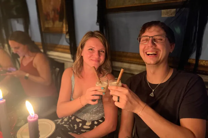 a woman sitting at a table with a birthday cake with lit candles