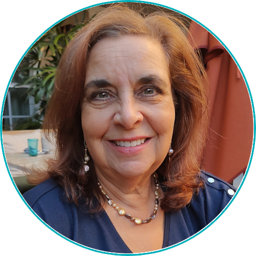 Smiling woman with brown hair, wearing a blue top, in a circular portrait setting.